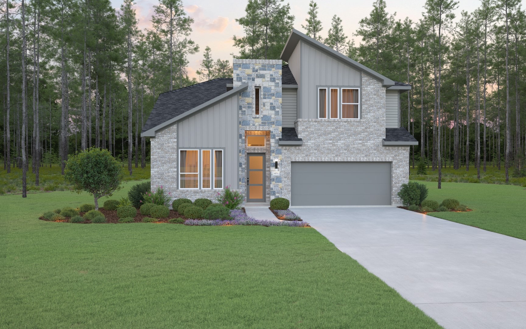 Modern two-story house with gray brick and siding, large front windows, a double garage, and a landscaped yard with green grass, bushes, and trees, set against a forest background at sunset.