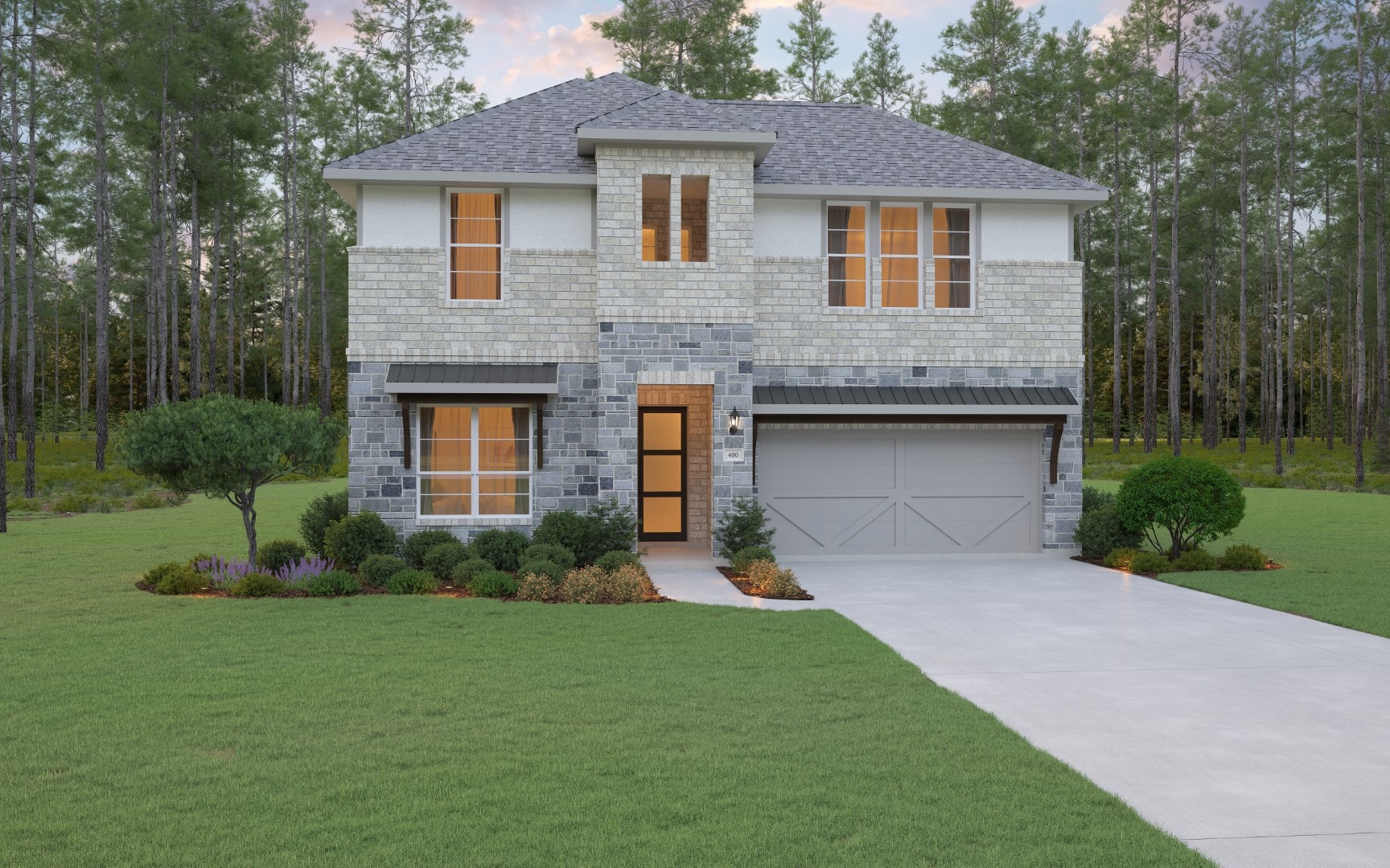 A modern two-story house with gray brick exterior, large windows lit from inside, a double garage, manicured shrubs, and a green lawn set against a backdrop of tall pine trees.